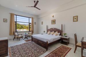a bedroom with a bed and a large window at Jass Bagh Home stay Udaipur With Bonefire And Pool in Udaipur