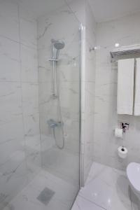 a bathroom with a shower with a glass door at Nestor Hotel in Ayia Napa