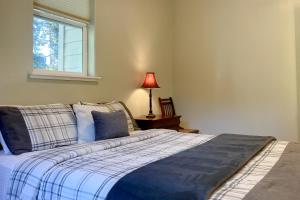 a bed in a bedroom with a window and a lamp at Balboa Bliss in McKinleyville