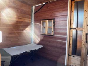 a room with a wooden wall with a window at Glamping Village LEAF in Mashiki