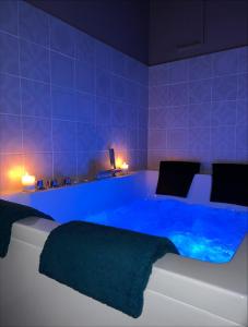 1 dormitorio con bañera azul en una habitación en SPA APPARTEMENT en Ermont