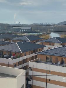 uma vista para os telhados dos edifícios e uma massa de água em Apartament Lucian em Râmnicu Vâlcea
