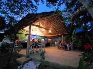 Watamu Beach Cottages B&B في واتامو: مجموعة من الناس يجلسون على طاولة في مطعم