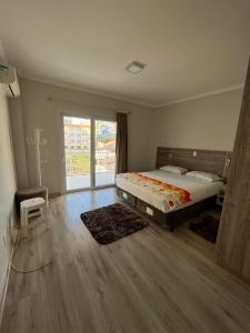 a bedroom with a bed and a large window at Apartamento na Avenida próximo das Termas in Piratuba