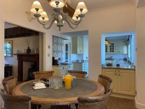 a kitchen with a wooden table with chairs and orange juice at The Farmhouse in Pontefract