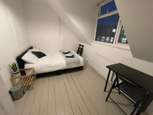 a small white bedroom with a bed and a window at Beautiful 2 Bedroom On Tower Bridge in London
