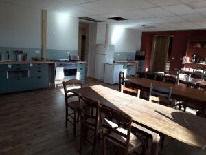 A la belle étoile في Mellionnec: مطبخ فيه طاولة وكراسي خشبية