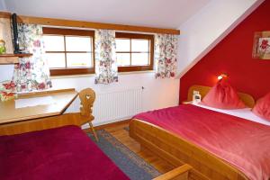 a bedroom with two beds and red walls at Hiaslahof in Mariapfarr