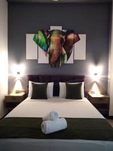 a bedroom with a large bed with paintings on the wall at Vimanra Udawalawa in Udawalawe +130 photos