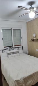 - une chambre avec un lit blanc et un ventilateur de plafond dans l'établissement Tamara Mar Menor, à San Javier