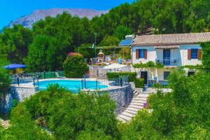 a resort with a swimming pool and a house at Old Stone House in Nisaki