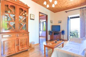 a living room with a large wooden entertainment center at Old Stone House in Nisaki