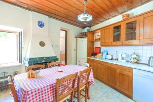 a kitchen with a table with a red and white checkered table cloth at Old Stone House in Nisaki