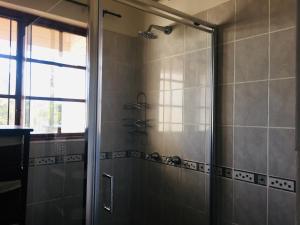 a shower with a glass door in a bathroom at Skills Tree 58 Pty Ltd in Empangeni