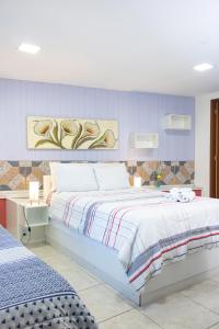 - une chambre avec 2 lits et un mur bleu dans l'établissement Pousada Estrela da Manhã, à São Pedro da Serra