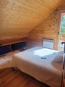 ラ・ジュー・デュ・ルーにあるChalet Hauts De La Lauzièreの木製の天井の客室のベッド1台分です。