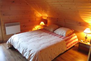 ラ・ジュー・デュ・ルーにあるChalet Hauts De La Lauzièreの木製の壁のベッドルーム1室(ベッド1台付)