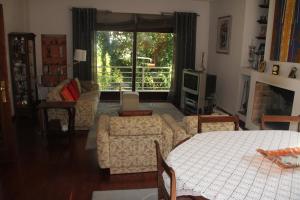 - un salon avec un lit, un canapé et une fenêtre dans l'établissement Cork Tree Villa, à Gondomar