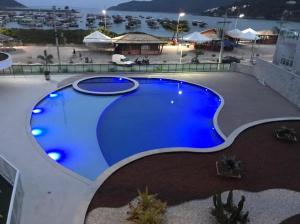a large blue swimming pool on top of a building at Nascer do sol 102 in Arraial do Cabo