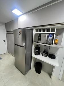 uma cozinha com um frigorífico de aço inoxidável e uma prateleira em Nascer do sol 102 em Arraial do Cabo
