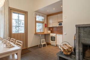 a kitchen with a fireplace and a table and chairs at Ski-Inn MastonAitio in Ruka +47 photos
