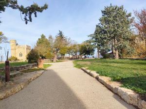 un chemin dans un parc avec un bâtiment en arrière-plan dans l'établissement Gîte chaleureux "Le Figuier" - Val-du-Faby, à Fa 12 autres photos