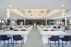 un gran salón de banquetes con mesas y sillas blancas en Occidental Roca Negra - Adults Only en Agaete