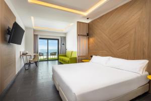 a hotel room with a bed and a television at Occidental Roca Negra - Adults Only in Agaete
