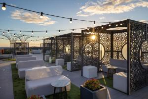 a patio with white chairs and tables and lights at Occidental Roca Negra - Adults Only in Agaete