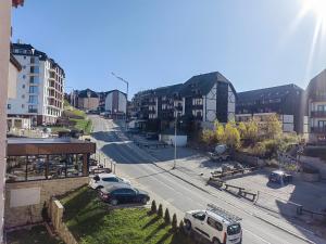 a city street with cars parked on the road at White Apartman Kopaonik in Kopaonik