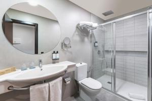 a bathroom with a sink and a toilet and a shower at Occidental Roca Negra - Adults Only in Agaete