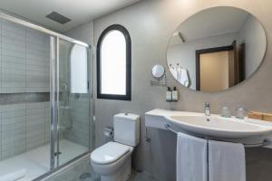 a bathroom with a sink and a toilet and a mirror at Occidental Roca Negra - Adults Only in Agaete