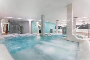 a large pool of blue water in a building at Occidental Roca Negra - Adults Only in Agaete