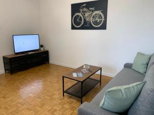 a living room with a couch and a tv and a table at APARTAMENT GERSONA in Bydgoszcz