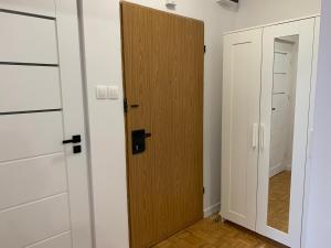 a closet with a wooden door in a room at APARTAMENT GERSONA in Bydgoszcz