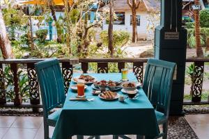 une table avec un chiffon de table bleu et de la nourriture dans l'établissement Baan Kiao, à Haad Yao