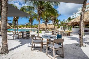 Blue Bay BEACH Villa 25 3-min beach-pool-golf في الخليج الأزرق: مطعم على الشاطئ به طاولات وكراسي
