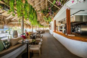 Blue Bay BEACH Villa 25 3-min beach-pool-golf في الخليج الأزرق: مطعم بالطاولات والكراسي والنباتات