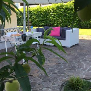 um pátio com um sofá e uma mesa em B&B Rivanazzano Tavernetta tra vino e terme em Rivanazzano