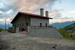 a building with a stone wall next to a hill at PS House Polydrosos - PS Rental in Polydrossos