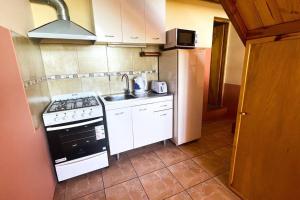 a small kitchen with a stove and a sink at Casa de Montaña Cerro Otto. Aventurate! in San Carlos de Bariloche