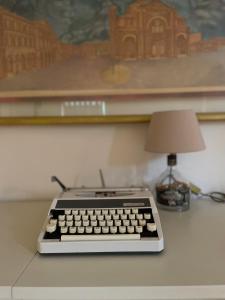 un teclado de ordenador sentado en un escritorio junto a una lámpara en B&B Rivanazzano Tavernetta tra vino e terme en Rivanazzano