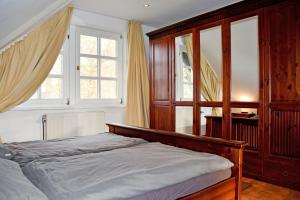 a bedroom with a bed and two windows at Reetdachfachwerkvilla am Wiesengrund in Bergen auf Rügen