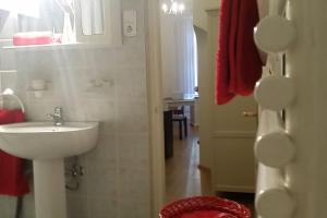 bagno con lavandino bianco e asciugamano rosso di AIRAM Apartment CENTER BUDAPEST a Budapest