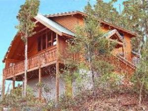 a house sitting on top of a hill with trees at Knotty By Nature in Gatlinburg