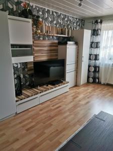 a room with a kitchen with wooden floors and a tv at 5 minutes from the fair in Hannover