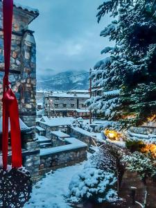 a christmas tree with a red ribbon in the snow at Charming 3-storey Loft with fireplace in Palaios Agios Athanasios