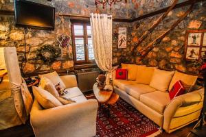 ein Wohnzimmer mit 2 Sofas und einem TV in der Unterkunft Charming 3-storey Loft with fireplace in Palaios Agios Athanasios