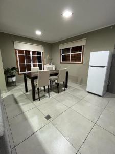 a dining room with a table and a white refrigerator at Casa Céntrica para alquiler vacacional in Puerto Iguazú