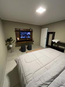 um quarto com uma cama e uma televisão de ecrã plano em Casa Céntrica para alquiler vacacional em Puerto Iguazú